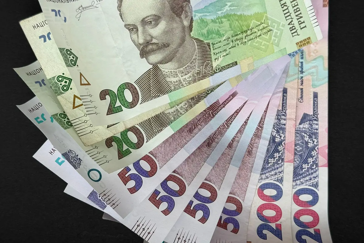 Віяло українських гривень різних номіналів на темному тлі